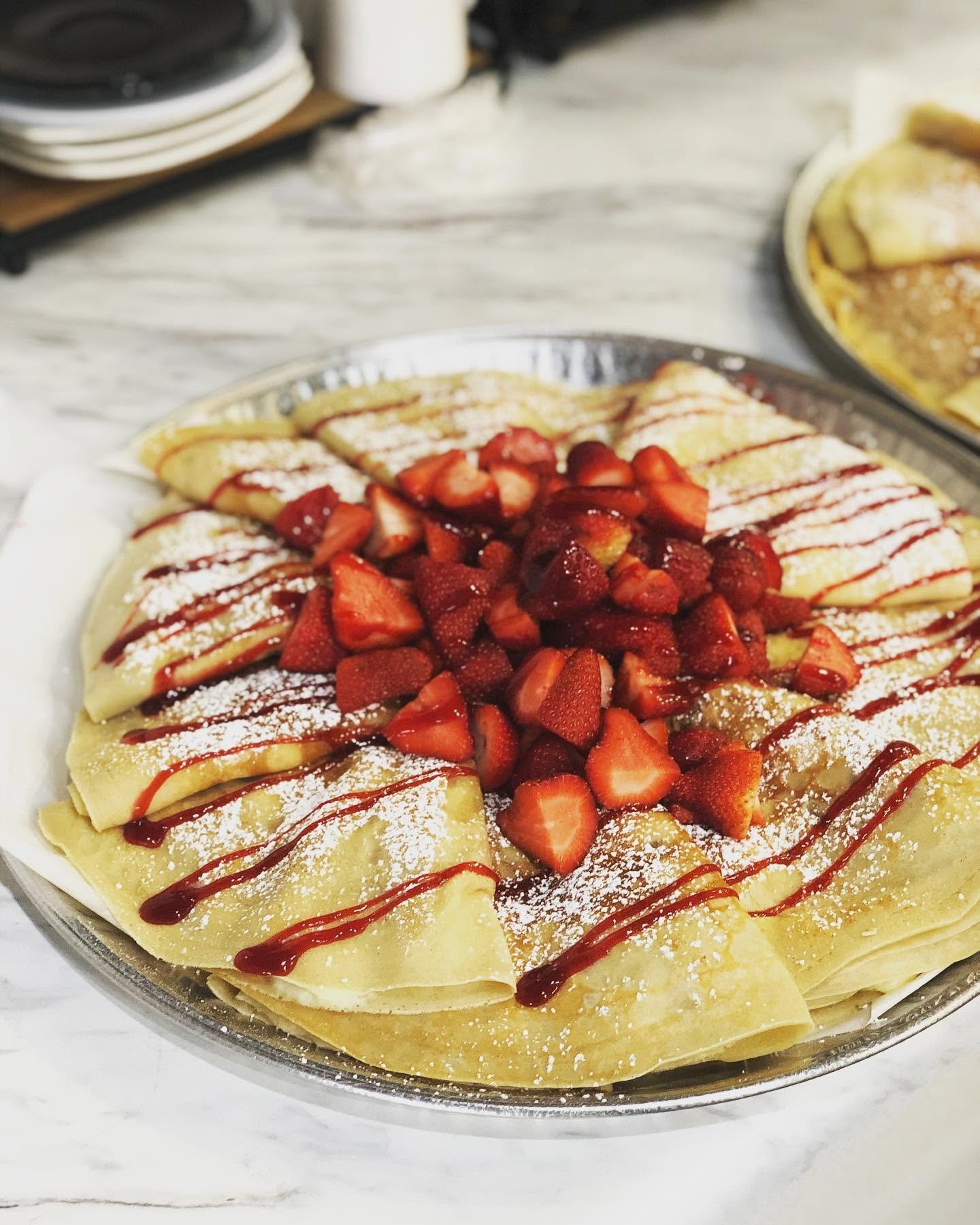 Strawberry crepes dusted with powdered sugar